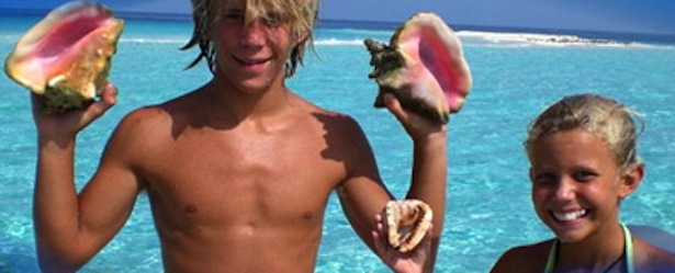 Kids holding Conch Shells in Turks and Caicos in the Caribbean